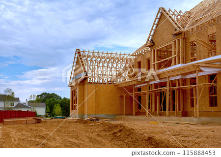 Newly constructed house with unfinished interior with wooden stud timber framing supports beams Newly constructed house with unfinished interior with wooden stud timber framing supports beams 115888453