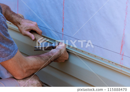 During construction facade of new home, handyman installed vinyl PVC siding 115888470