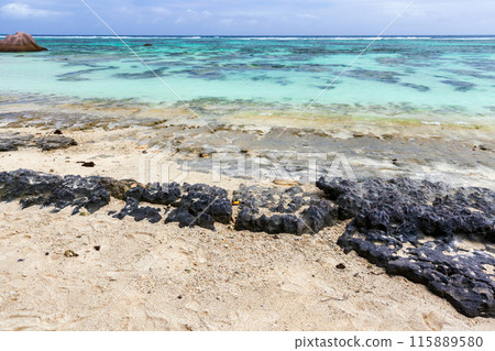 Sharp rocks at the coast of Anse Union beach. Coastal landscape Sharp rocks at the coast of Anse Union beach. Coastal landscape 115889580
