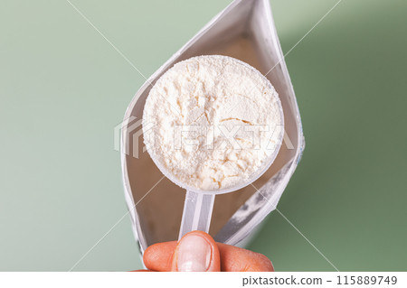 Protein powder measuring spoon in hand 115889749