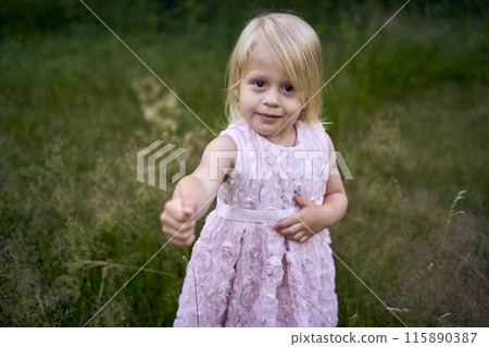a little girl holds out a bouquet of field herbs a little girl holds out a bouquet of field herbs 115890387