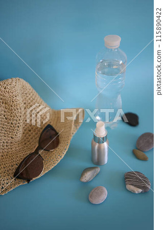 straw hat, sunglasses, bottle of water, sun spray, pebbles on a colored background straw hat, sunglasses, bottle of water, sun spray, pebbles on a colored background 115890422