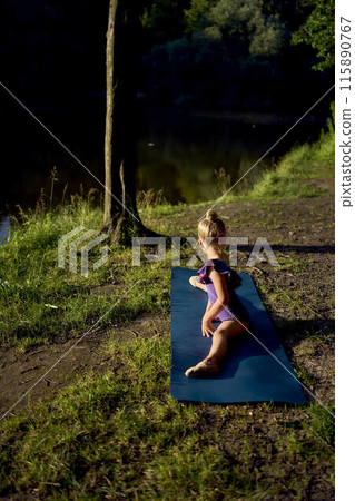 a llittle 5-year-old girl in a black minimalist jumpsuit does gymnastics by the river, outdoors a llittle 5-year-old girl in a black minimalist jumpsuit does gymnastics by the river, outdoors 115890767