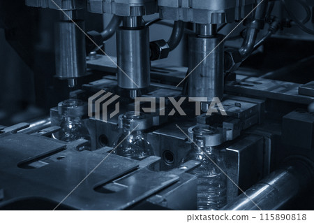 The drinking water bottle manufacturing process by blow mold machine in the light blue scene. The drinking water bottle manufacturing process by blow mold machine in the light blue scene. 115890818