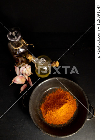 Overhead image of condiments and ingredients on black table. 115891547