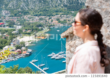 Blurred woman looks at the beautiful Boko Kotor Bay of Montenegro. Panoramic view. Summer vacation 115891640