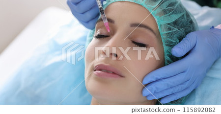 Beautician gives woman rejuvenating injection into skin of face Beautician gives woman rejuvenating injection into skin of face 115892082