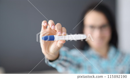 Woman holds pregnancy test in her hand 115892190