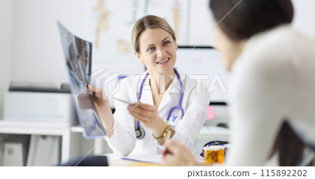 Female doctor shows patient an X-ray closeup Female doctor shows patient an X-ray closeup 115892202
