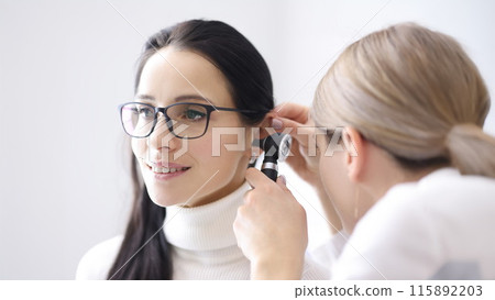 Doctor conducts examinations of ear area for woman Doctor conducts examinations of ear area for woman 115892203