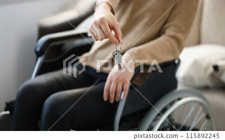 Woman in wheelchair holds keys to apartment 115892245