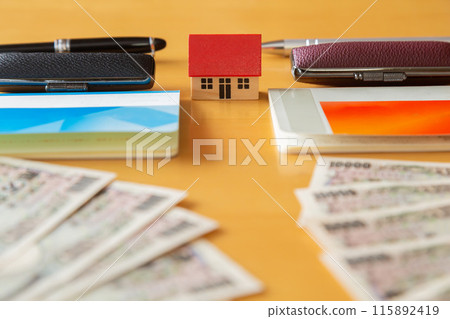 兩本存摺、郵票、10,000日元鈔票和房子錢圖像 115892419