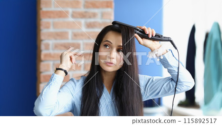 Brunette woman does curling of her hair with curling iron Brunette woman does curling of her hair with curling iron 115892517