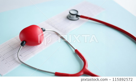 Red toy heart and stethoscope lying on cardiogram closeup Red toy heart and stethoscope lying on cardiogram closeup 115892572