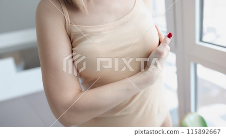 Woman hand examining mammary gland at home closeup 115892667