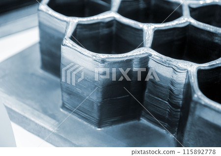 Object printed by 3D printer from metal. Additive manufacturing solution. Object created on 3Dprinter from melting metal thread. 3D Metal Printing. Metal additive manufacturing Object printed by 3D printer from metal. Additive manufacturing solution. Object created on 3Dprinter from melting metal thread. 3D Metal Printing. Metal additive manufacturing 115892778
