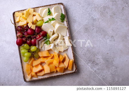 Cheese plate with different cheese, grapes and melon. Cheese plate with different cheese, grapes and melon. 115893127