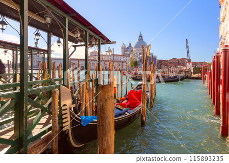 Black gondola near the pier on the Grand Canal in Venice. Black gondola near the pier on the Grand Canal in Venice. 115893235