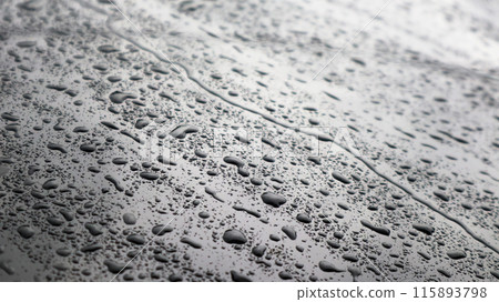 This image captures raindrops on a dark surface, highlighting their glistening clarity and natural beauty. This image captures raindrops on a dark surface, highlighting their glistening clarity and natural beauty. 115893798