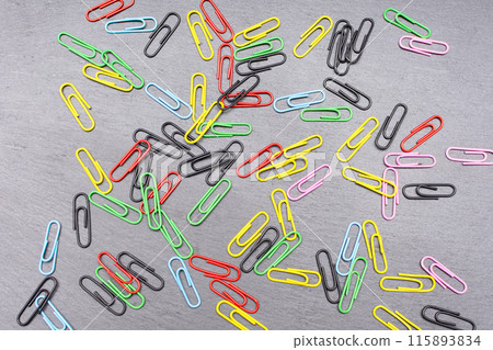 colored paper clips on a dark background colored paper clips on a dark background 115893834