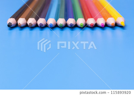 colored wooden pencils on a blue background colored wooden pencils on a blue background 115893920