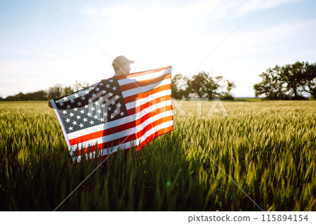 Man hold waving american USA flag. Patriot raise national american flag. Independence Day, 4th July. 115894154