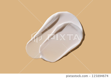 A smear of white cream on a beige background. A smear of white cream on a beige background. 115894674