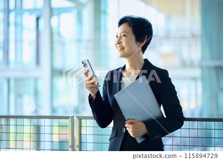 middle business woman with smartphone in office 115894729