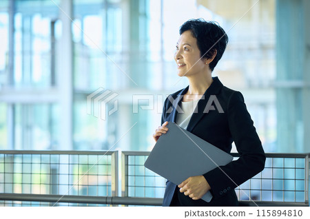 帶著微笑的筆記本電腦的中層女商人 115894810