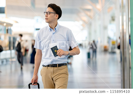 A man walking through an airport lobby A man walking through an airport lobby 115895410