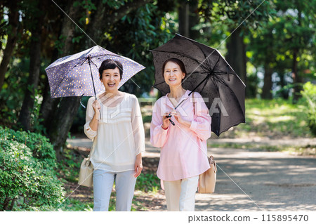 A middle-aged woman walking with a parasol 115895470