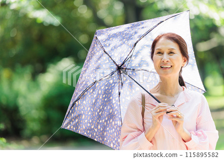 撐著陽傘走路的中年婦女 撐著陽傘走路的中年婦女 115895582