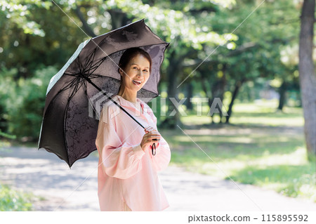 A middle-aged woman walking with a parasol A middle-aged woman walking with a parasol 115895592