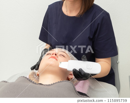 Young woman getting ultrasonic peel skin with skin scrubber. Young woman getting ultrasonic peel skin with skin scrubber. 115895739