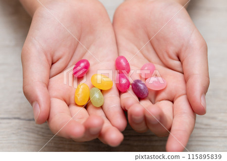 拿著五顏六色的糖果的孩子的手 拿著五顏六色的糖果的孩子的手 115895839