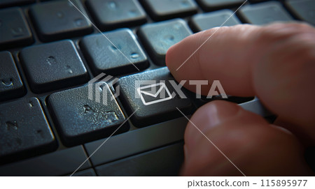 Close-up of hand pressing email icon on keyboard Close-up of hand pressing email icon on keyboard 115895977
