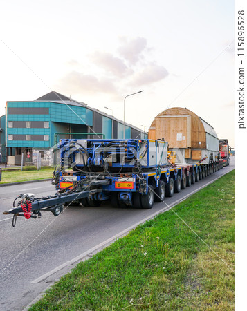 Very long specialized multi axle truck trailer carries very heavy oversize load, rear view Very long specialized multi axle truck trailer carries very heavy oversize load, rear view 115896528