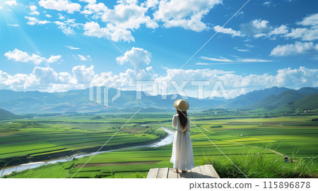 A young woman in a white dress looking out over a vast plain 115896878
