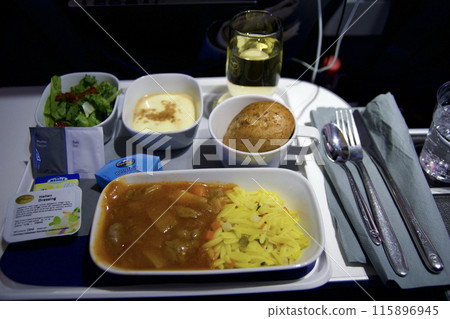 FRANKFURT, GERMANY - JUNE 10, 2019: Hot airplane food on a tablet in the Premium Economy of an airline on the flight to Dubai 115896945