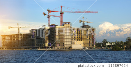 Tower cranes and frame structure of high residential apartment buildings at construction site. Real estate development 115897624