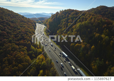 View from above of I-40 freeway in North Carolina heading to Asheville through Appalachian mountains in golden fall season with fast driving trucks and cars. Interstate transportation concept 115897627