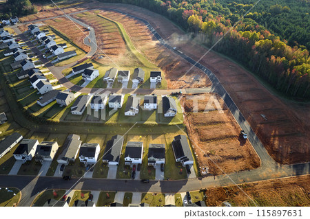 Aerial view of real estate development with tightly located family houses under construction in Carolinas suburban area. Concept of growing american suburbs Aerial view of real estate development with tightly located family houses under construction in Carolinas suburban area. Concept of growing american suburbs 115897631