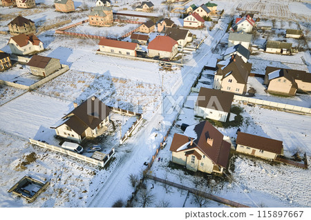 Aerial view of residential houses with snow covered roofops in suburban rural town area in winter 115897667