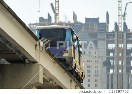 City train car on high railroad over street traffic between skyscraper buildings in modern American megapolis. Urban transportation in downtown district of Miami Brickell in Florida USA 115897702