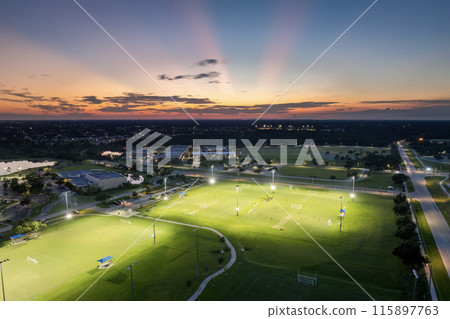 Public sports stadium with young people playing football game at sunset. Active way of life concept 115897763