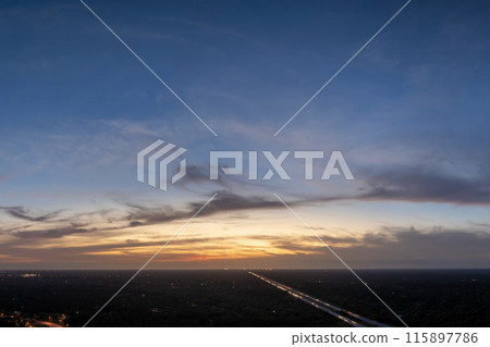 Bright colorful orange and yellow clouds over dark horizon. Beautiful sunset sky scenery Bright colorful orange and yellow clouds over dark horizon. Beautiful sunset sky scenery 115897786