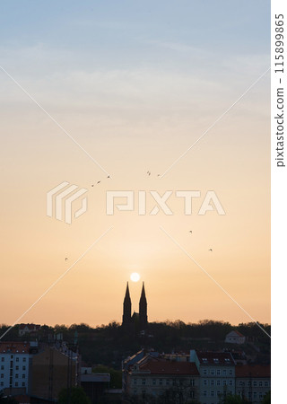 Silhouette of two towers of Vyshegrad church at sunrise in Prague, Czech Republic. Morning sun among two church towers. 115899865