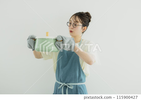 站在廚房裡的年輕女子 115900427