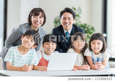 Elementary school students and a teacher taking a programming class at a cram school. 115900525