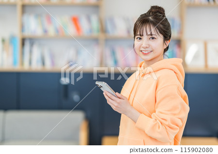 A young woman operating a smartphone. 115902080